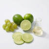 Fresh lemon slices, grapes, and a laboratory flask with fruit acid extract on a white background.
